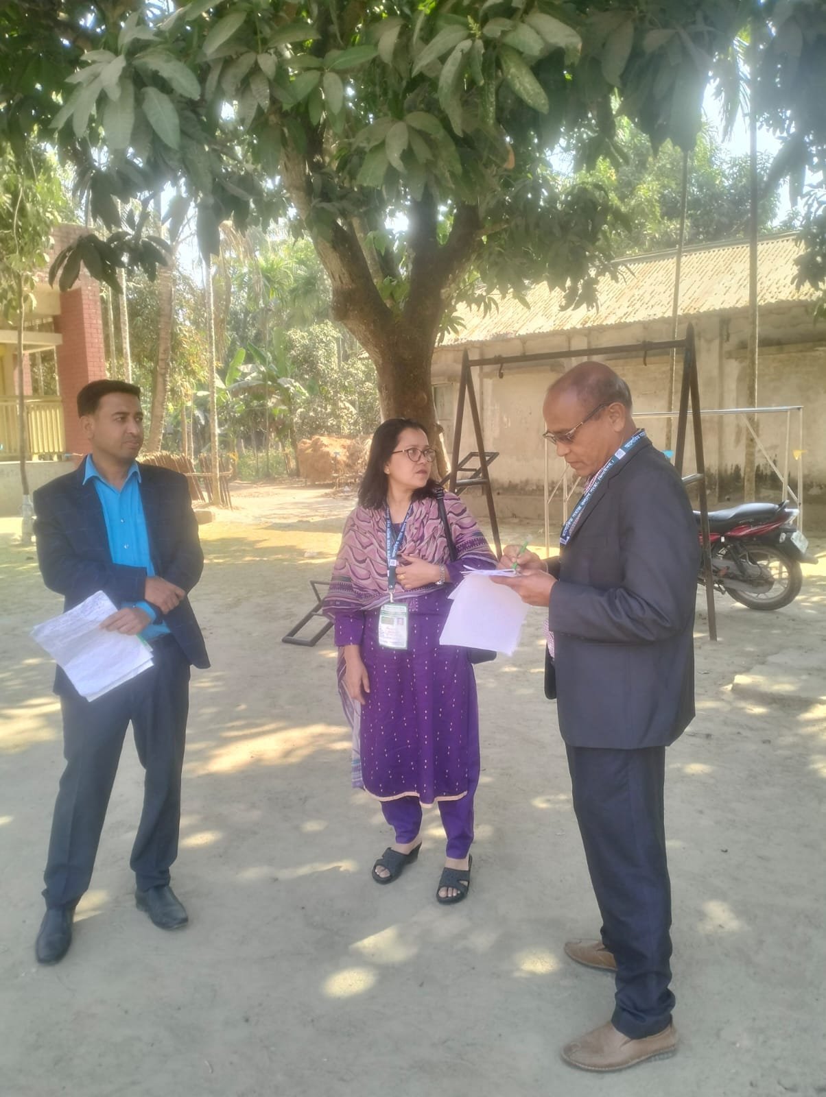 Official handing a document to a woman in a field.
